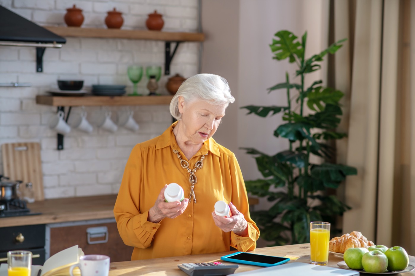 A woman reading the label on a supplement tub
